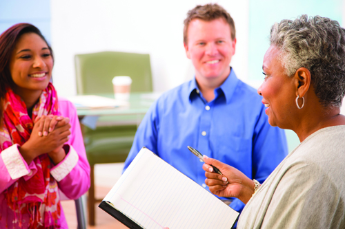 A group of three people talking together.